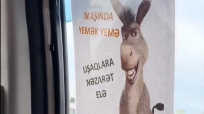 Taksi sürücüsündən sərnişinlərə təhqir: Maşının şüşəsinə eşşək şəkli yapışdırdı - VİDEO 