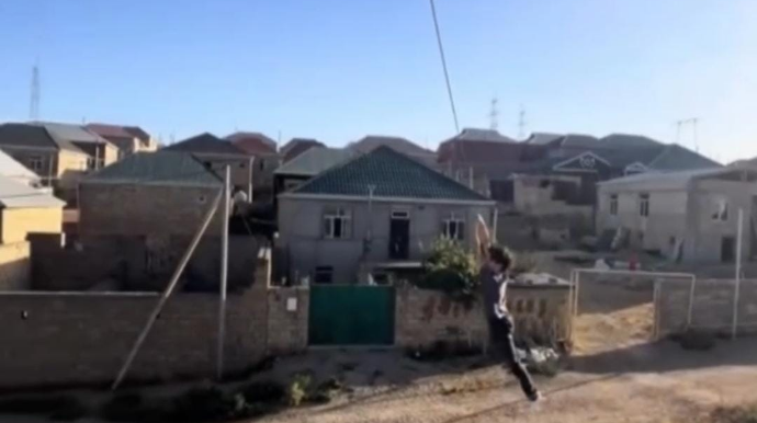 Bakıda yeniyetmə dirəkdən qopan elektrik naqilindən sallaşıb görün nə etdi - VİDEO 