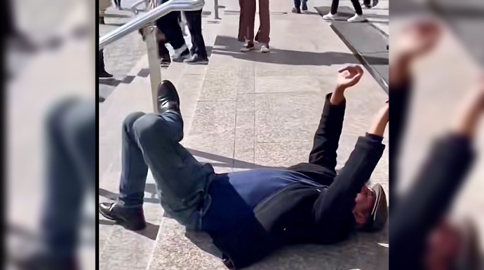 Sərxoş kişi 28 May metrosunun qarşısında yerə uzanıb oynadı  - VİDEO 