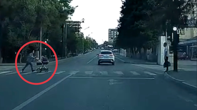 Qırmızı işıqda uşaq arabası ilə yola qaçan qadın təhlükə yaratdı - VİDEO