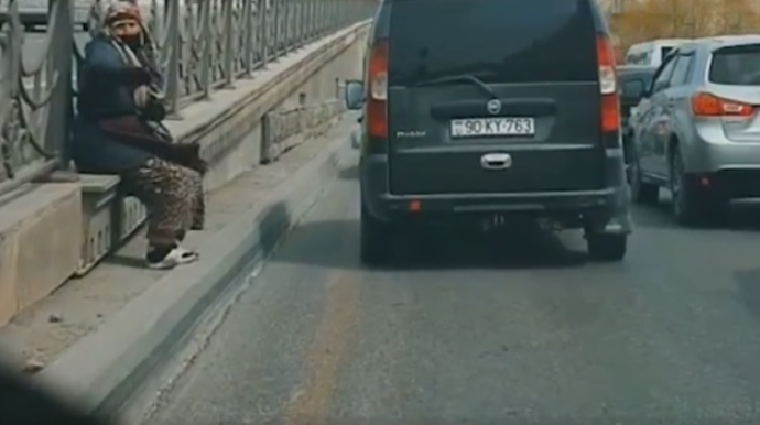 Bakıda yaşlı qadın sürücüləri "Azəravtoyol"-un çuxurundan qoruyur - VİDEO 