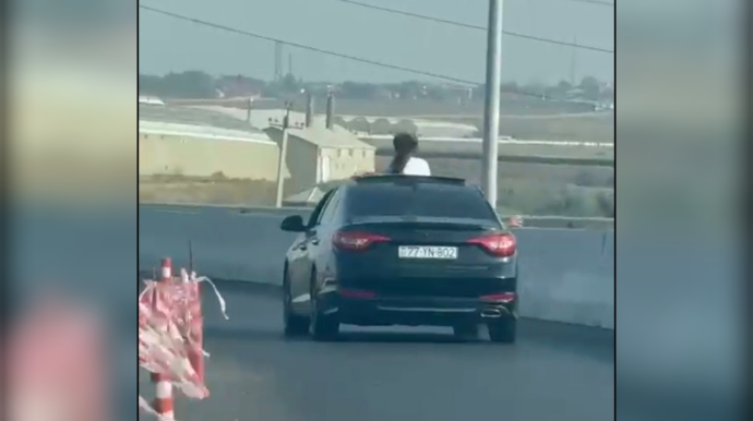 В Баку женщина решила развлечься, высунувшись из люка автомобиля - ВИДЕО 