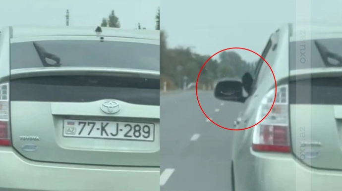 Ayağını yolboyu pəncərədən çıxaran sürücü təhlükə saçdı - VİDEO