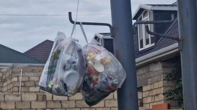 “Torbalara yığılaraq divardan asılıb” -  Bakıda məişət tullantıları problemi - VİDEO 