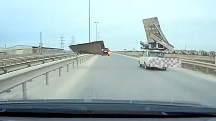 Binəqədidə təhlükəli anlar: “VAZ”ın damından uçan yüklər arxadakı maşına dəydi   - VİDEO