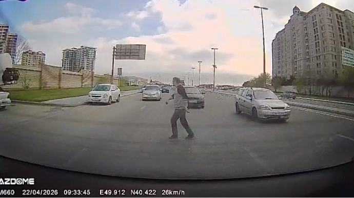 Hərəkətdə olan maşınların qarşısına çıxan piyada barmaqla yol istədi   - VİDEO