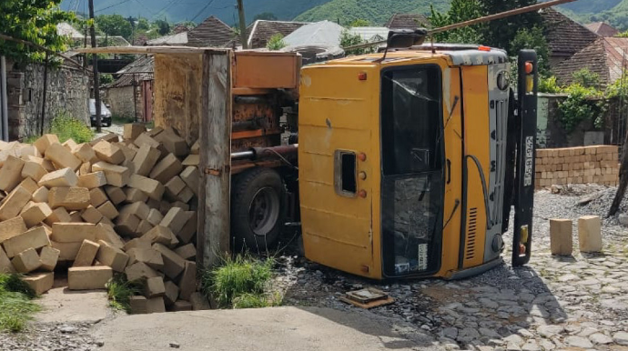 Şəkidə yük boşaldarkən “KamAZ” aşdı, sürücü xəsarət aldı - FOTO