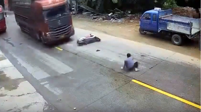 Motosikletdən yola yıxılan sürücünü ağır yük maşını vurdu - VİDEO 