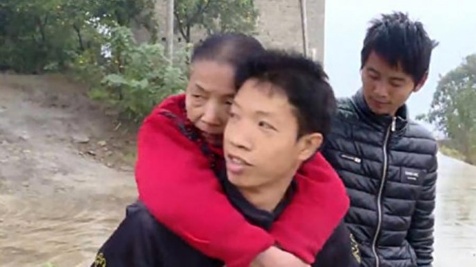 Çin sakini 15 ildir xəstə anasını belində gəzdirir