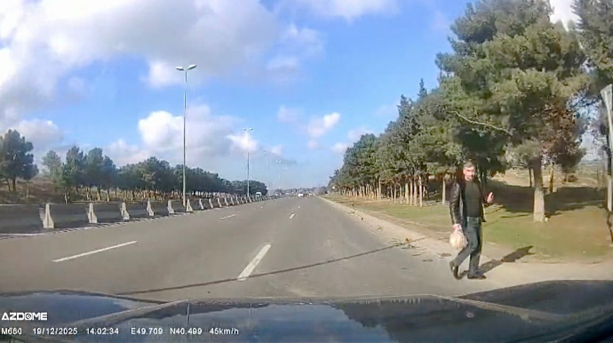 Başı telefona qarışan piyada yolu istədiyi yerdən keçərək təhlükə yaratdı   - VİDEO