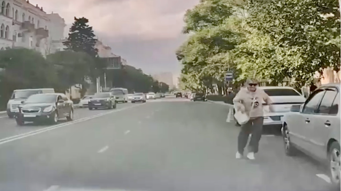 Park edilmiş avtomobillərin arasından yola qaçan qadın riskli vəziyyət yaratdı   - VİDEO