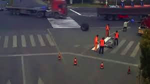 Nəhəng təkər yolda xətt çəkən işçinin üzərində keçdi - VİDEO