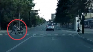 Qırmızı işıqda uşaq arabası ilə yola qaçan qadın təhlükə yaratdı - VİDEO