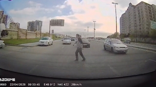 Hərəkətdə olan maşınların qarşısına çıxan piyada barmaqla yol istədi   - VİDEO