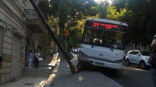 Bakının mərkəzində QORXULU ANLAR:  Avtobus işıq dirəyini binanın üstünə aşırdı  - FOTO