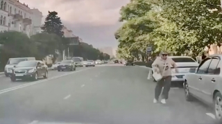 Park edilmiş avtomobillərin arasından yola qaçan qadın riskli vəziyyət yaratdı   - VİDEO